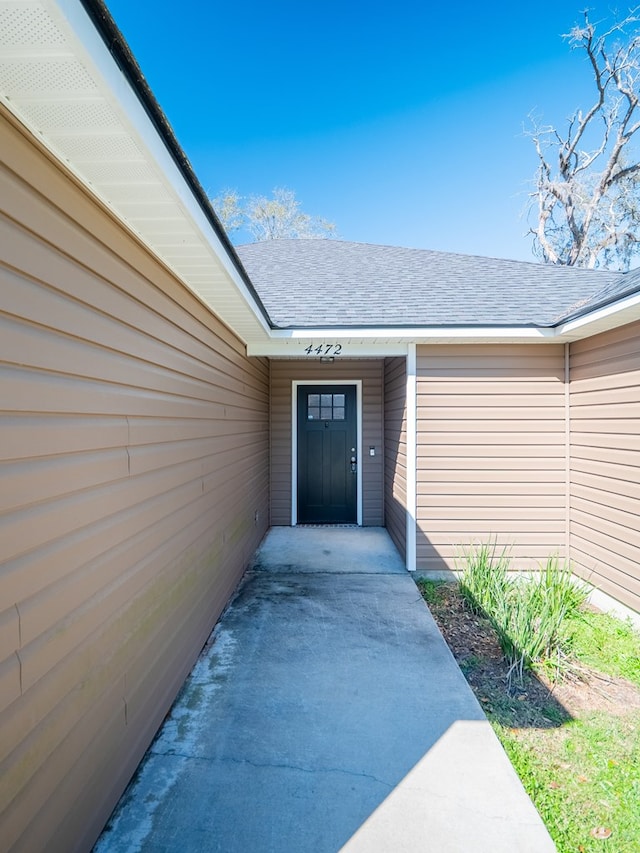 property entrance featuring a shingled roof