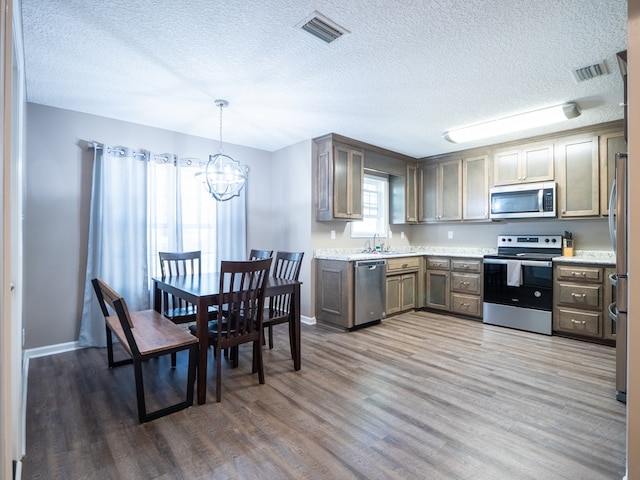 kitchen with visible vents, light wood-style floors, appliances with stainless steel finishes, and light countertops