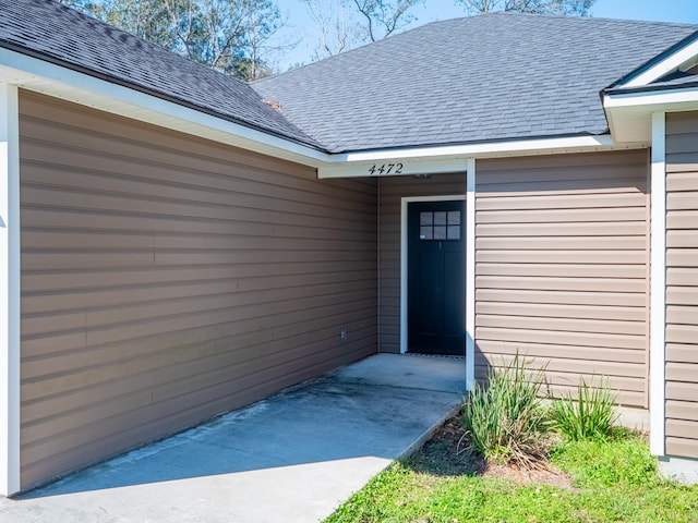 property entrance with a shingled roof