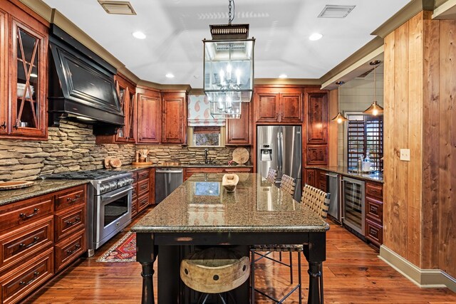 kitchen with pendant lighting, a breakfast bar area, stainless steel appliances, a center island, and wine cooler