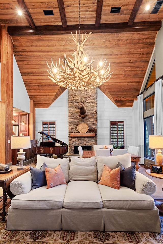 living room with a notable chandelier, beam ceiling, a fireplace, and wooden ceiling