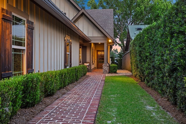 exterior entry at dusk featuring a yard