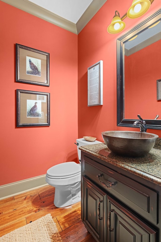 bathroom with vanity, hardwood / wood-style floors, crown molding, and toilet