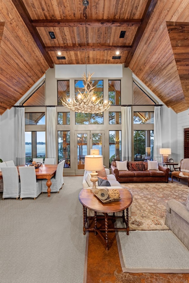 living room with beamed ceiling, plenty of natural light, wood ceiling, and an inviting chandelier