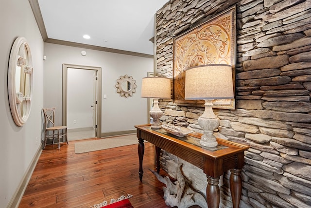 corridor with hardwood / wood-style floors and ornamental molding