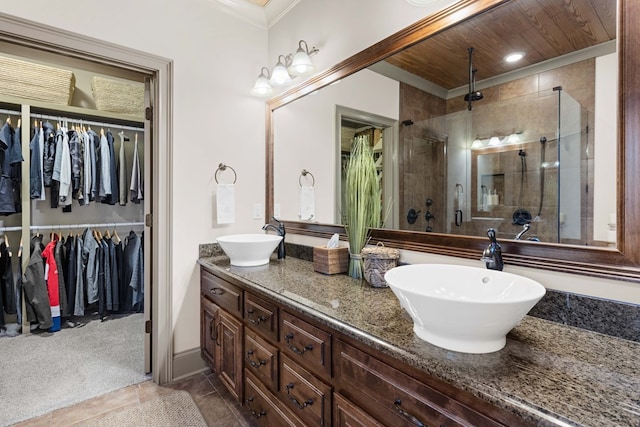 bathroom with a shower with door, vanity, and ornamental molding