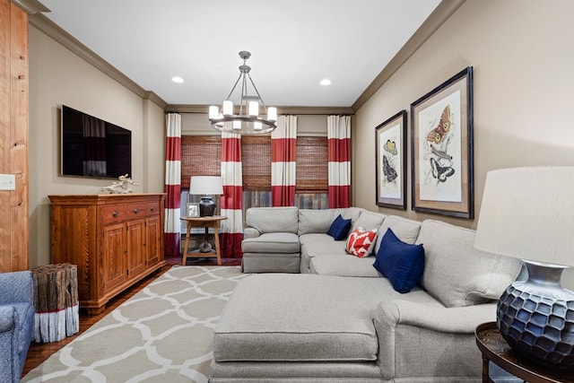 living room with ornamental molding, wood-type flooring, and a chandelier