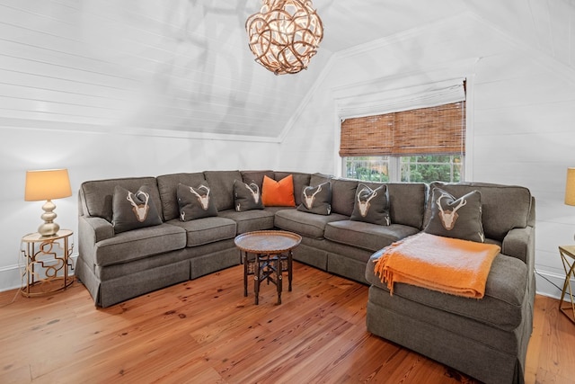 living room featuring vaulted ceiling, an inviting chandelier, and hardwood / wood-style floors