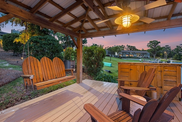 deck at dusk featuring a gazebo and ceiling fan