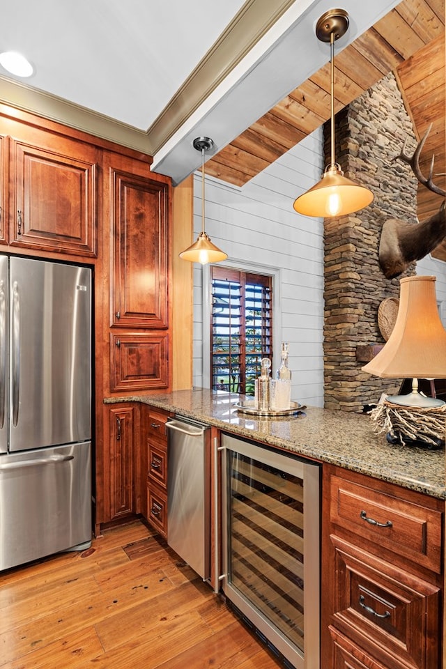 kitchen with wine cooler, light stone counters, hanging light fixtures, appliances with stainless steel finishes, and light hardwood / wood-style floors