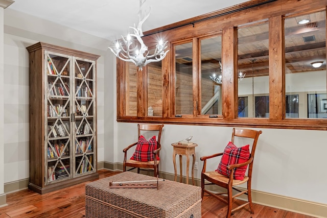 sitting room featuring hardwood / wood-style flooring and a notable chandelier