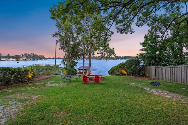 yard at dusk with a water view and a gazebo