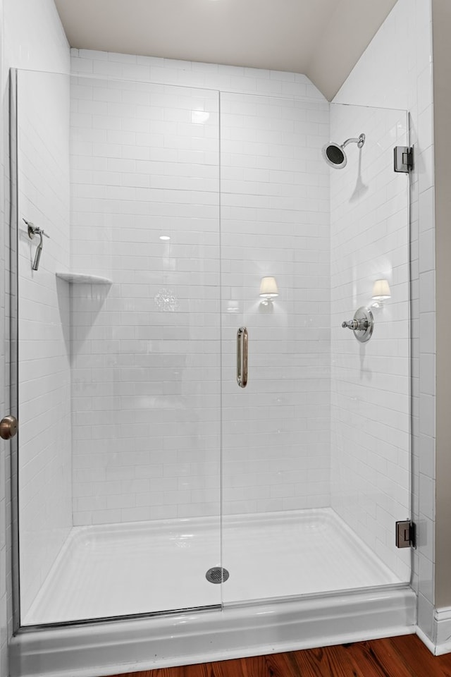 bathroom with an enclosed shower and wood-type flooring