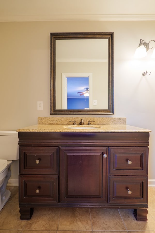 bathroom featuring vanity, ornamental molding, and toilet