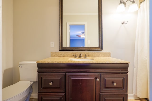 bathroom featuring vanity, crown molding, and toilet