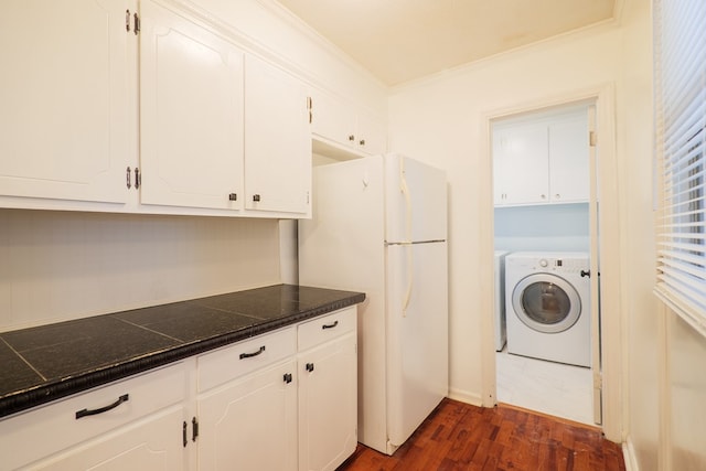 washroom with washer / dryer, dark hardwood / wood-style floors, ornamental molding, and cabinets