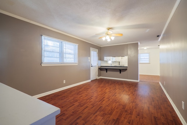 unfurnished living room with crown molding, dark hardwood / wood-style floors, a textured ceiling, and ceiling fan