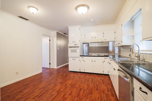 kitchen with sink, white cabinetry, dark hardwood / wood-style flooring, stainless steel dishwasher, and oven