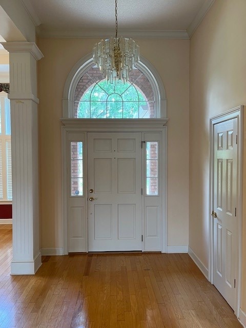 5054 Hammock Trl, Lake Park, GA 31636 - foyer featuring a chandelier, ornate columns, light wood-style floors, healthy amount of natural light, and ornamental molding