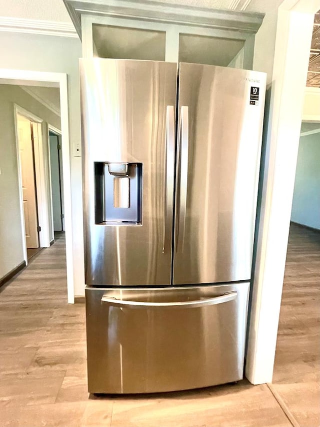 kitchen with stainless steel refrigerator with ice dispenser, ornamental molding, and light wood-type flooring