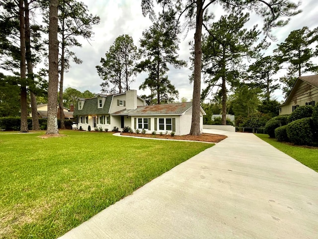 cape cod home with a front yard