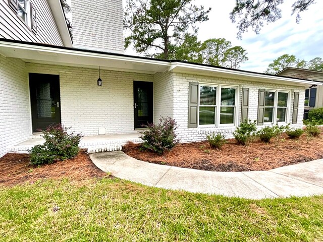 entrance to property with a lawn