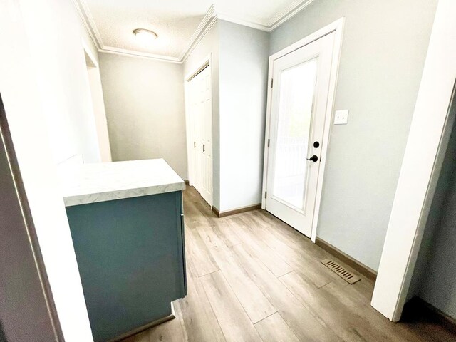 foyer featuring crown molding and light wood-type flooring