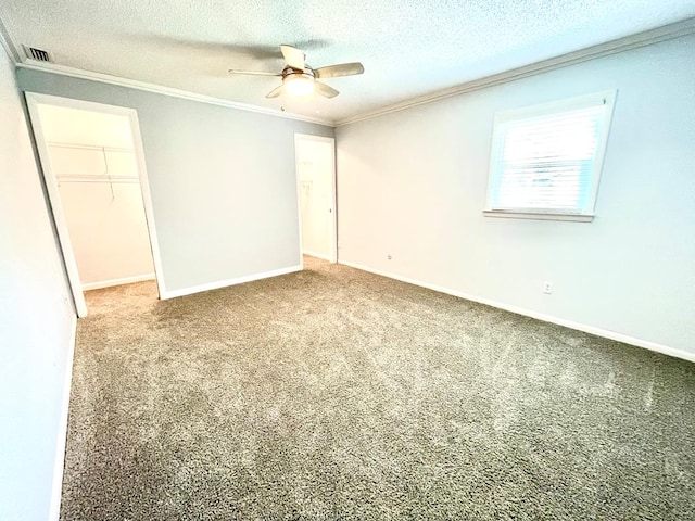 carpeted spare room featuring crown molding, ceiling fan, and a textured ceiling