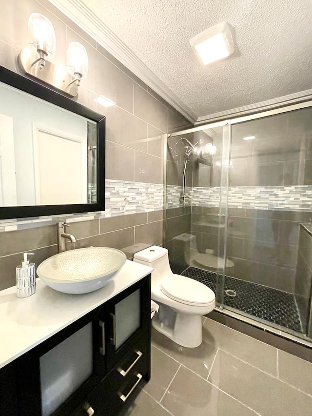 bathroom with tile walls, an enclosed shower, crown molding, and a textured ceiling