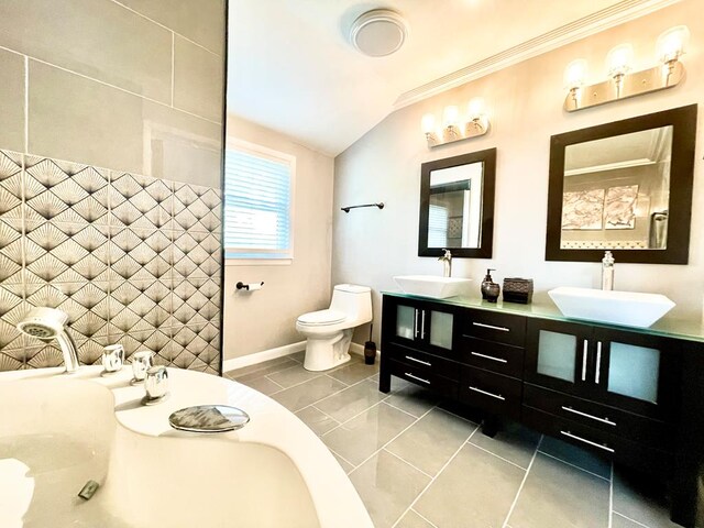 bathroom with crown molding, vanity, toilet, and vaulted ceiling