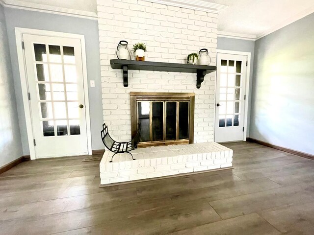 interior space with ornamental molding, a brick fireplace, and wood-type flooring