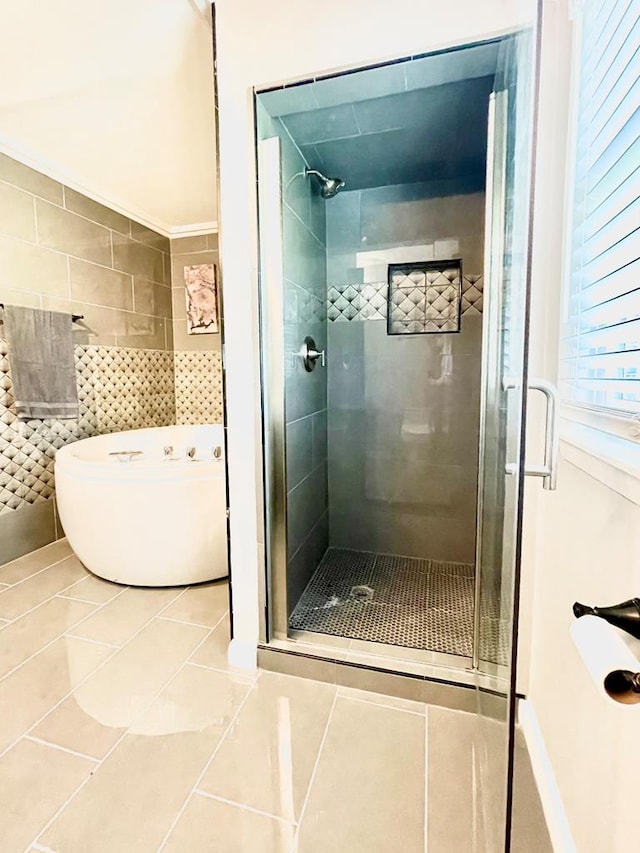 bathroom featuring tile patterned floors, a shower with shower door, and tile walls