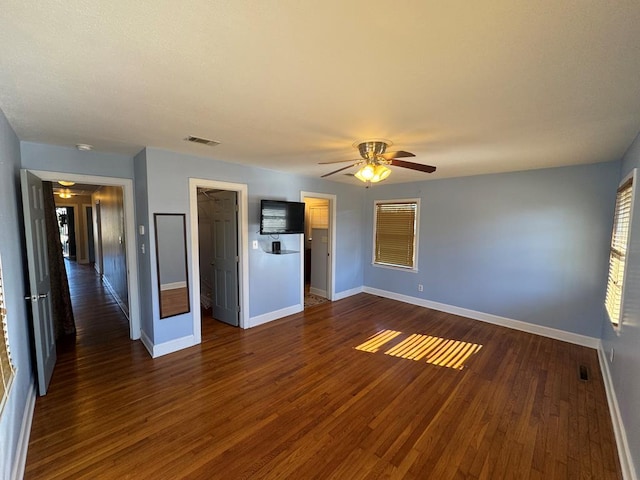 unfurnished living room featuring dark hardwood / wood-style floors and ceiling fan