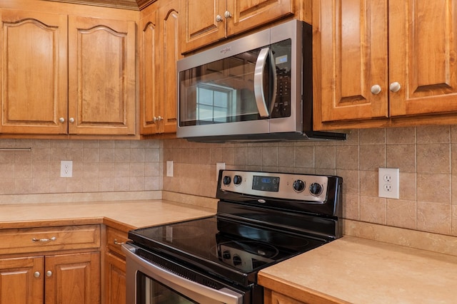 247 Harlee Ln, Ray City, GA 31645 - kitchen featuring appliances with stainless steel finishes, light countertops, backsplash, and brown cabinets