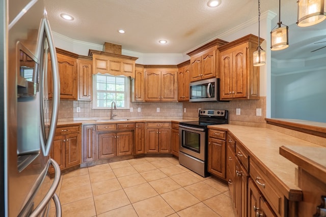 247 Harlee Ln, Ray City, GA 31645 - kitchen with stainless steel appliances, crown molding, brown cabinetry, light countertops, and decorative light fixtures