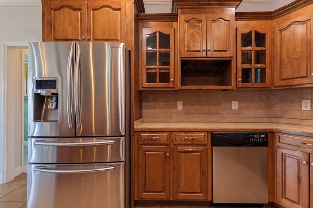 247 Harlee Ln, Ray City, GA 31645 - kitchen featuring stainless steel appliances, light countertops, light tile patterned floors, brown cabinetry, and glass insert cabinets