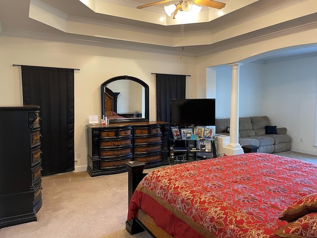 carpeted bedroom featuring crown molding, decorative columns, a raised ceiling, and ceiling fan