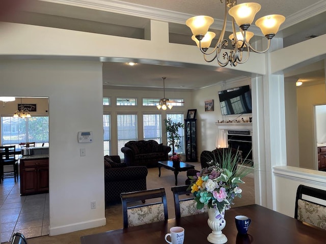 dining space featuring ornamental molding, a high end fireplace, and a notable chandelier