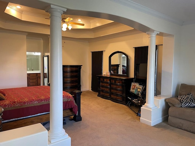 bedroom with a tray ceiling, ornamental molding, ceiling fan, and ornate columns