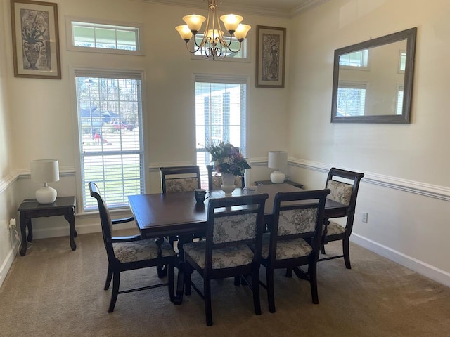 dining room with crown molding, carpet flooring, and a chandelier