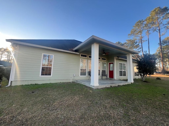 rear view of property featuring a patio, ceiling fan, and a lawn