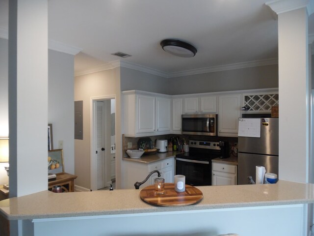2502B Jerry Jones Dr Unit 3, Valdosta, GA 31602 - kitchen featuring decorative backsplash, visible vents, appliances with stainless steel finishes, white cabinets, and ornamental molding
