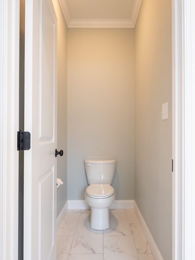 bathroom with ornamental molding and toilet