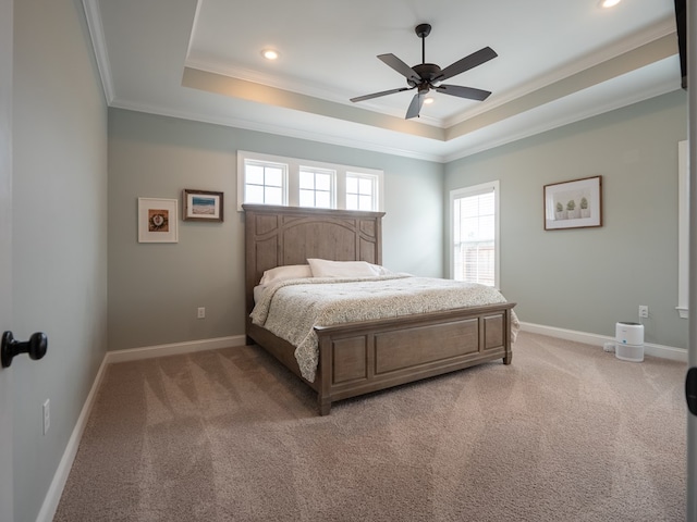 carpeted bedroom with crown molding, ceiling fan, and a tray ceiling