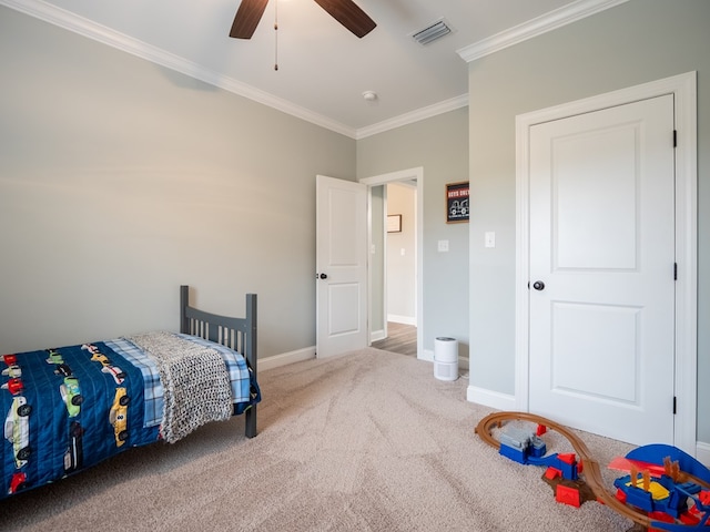 carpeted bedroom featuring crown molding and ceiling fan