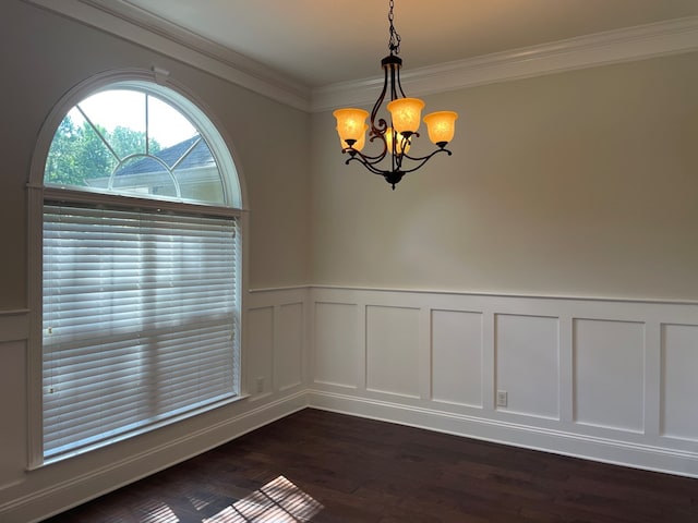 spare room with ornamental molding, dark wood-type flooring, and a chandelier