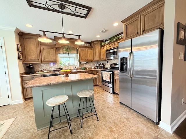 4172 Bright Crk, Hahira, GA 31632 - kitchen featuring appliances with stainless steel finishes, backsplash, a center island, a textured ceiling, and hanging light fixtures