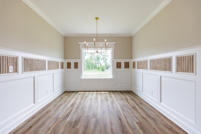 3061 Houser Way, Hahira, GA 31632 - unfurnished dining area with a decorative wall, a chandelier, wood finished floors, a wainscoted wall, and crown molding