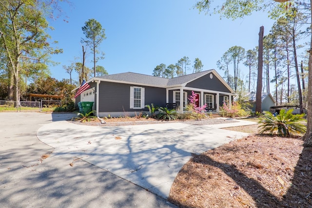 view of front of home with a porch, fence, a garage, and driveway