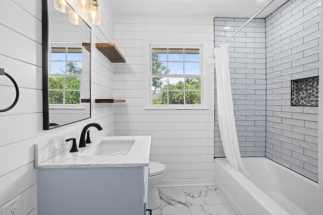 bathroom featuring wooden walls, shower / tub combo with curtain, vanity, toilet, and marble finish floor